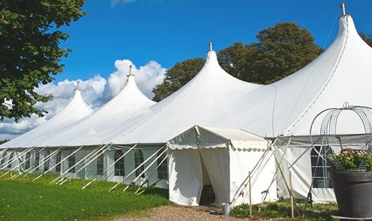 tall green portable restrooms assembled at a music festival, contributing to an organized and sanitary environment for guests in Baldwin